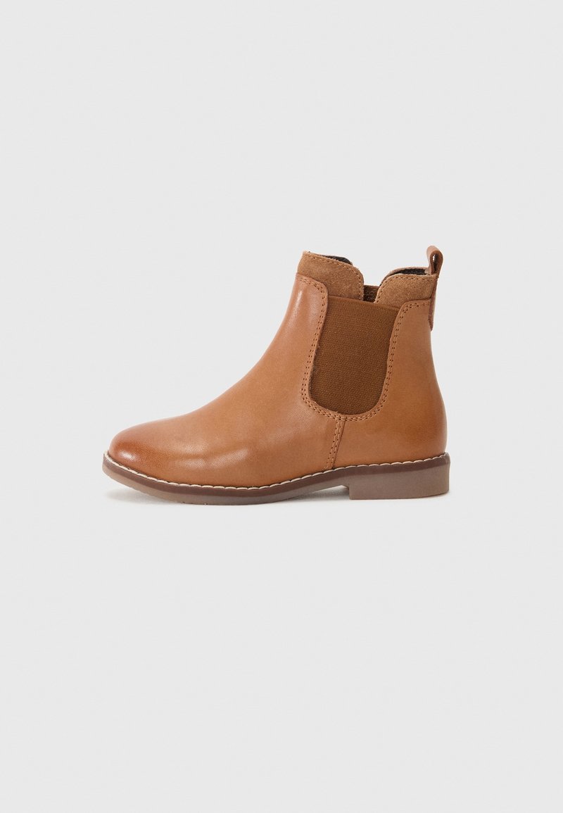 Bottine en cuir marron clair avec panneaux latéraux élastiques, languette à l'arrière et semelle basse plate sur un fond uni.