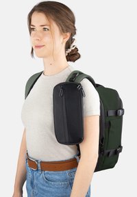 Rucksack mit einer schwarzen Reißverschlusstasche und gr�ünen Trägern. Hergestellt aus strapazierfähigem Stoff, mit einer strukturierten Form und seitlichen Schnallen.