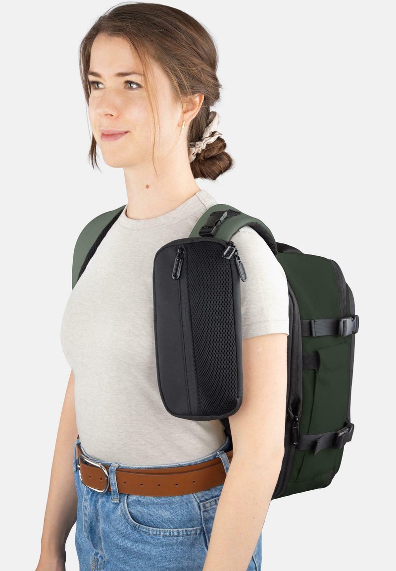 Rucksack mit einer schwarzen Reißverschlusstasche und grünen Trägern. Hergestellt aus strapazierfähigem Stoff, mit einer strukturierten Form und seitlichen Schnallen.