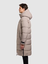 Bež jakna s kapuljačom, prošivenim dizajnom, bočnim patentnim zatvaračima i crnim detaljima. Ima duljinu do koljena i glatku, teksturiranu površinu.