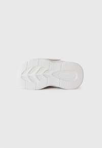 White sneaker sole with textured tread pattern and subtle branding in the center, photographed from the bottom on a plain background.