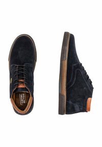 Navy suede shoes with brown leather accents, round toe, and beige rubber sole. Features laces and a cushioned inner lining.