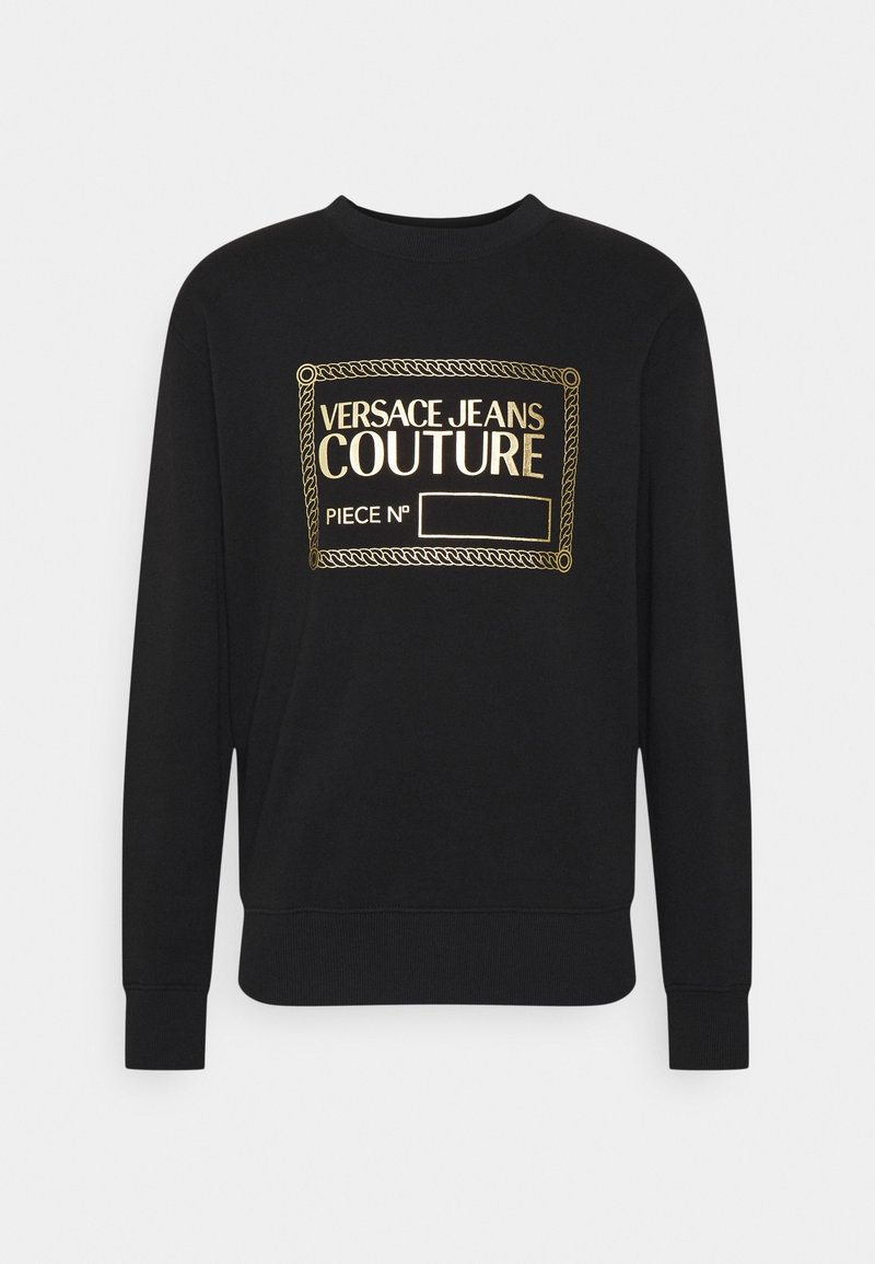 Svart sweatshirt med lång ärm och guld "Versace Jeans Couture"-logotyp samt dekorerande ram på bröstet, tomt utrymme för stycknummer.