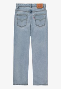 Vaqueros de mezclilla azul claro con corte recto, dos bolsillos traseros y una etiqueta de cuero marrón en la cintura. Detalle distintivo de costura.