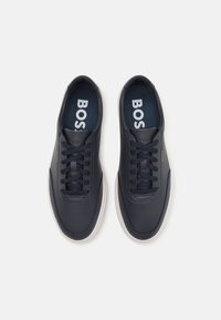 Navy blue leather sneakers with a white rubber sole, featuring round laces and a padded collar, branded "BOSS" on the tongue and insole.