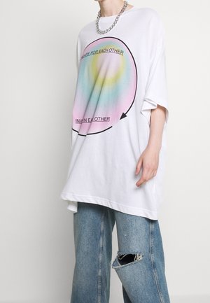 Przesadna biała koszulka z grafiką w postaci wielokolorowego gradientowego okręgu, na którym widnieją napisy "TWÓRZMY DLA SIEBIE" oraz "ZAPRASZAJMY SIĘ" z przodu.