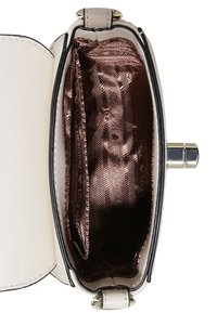 Krämfärgad läderhandväska med en strukturerad form. Inuti fodrad med glänsande brunt tyg med ett texturerat mönster. Låsning upptill.