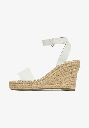 Sandali con zeppa in pelle bianca con suola in espadrilles testurizzata, cinturino alla caviglia regolabile e design semplice con hardware minimalista.