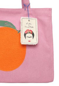 Borsa tote rosa con un motivo fluffy arancione e una foglia verde, e un'etichetta che mostra un volto con fiori. Realizzata in tessuto resistente.