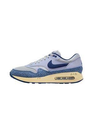 Chaussure de sport bleu et gris avec une superposition en maille bleue texturée, des panneaux gris clair lisses et un amorti d'air visible dans la semelle.