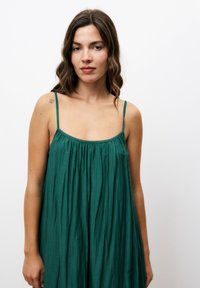 Groene mouwloze jurk van luchtige stof, met een gathered halslijn en delicate bandjes, met een losse, relaxte pasvorm.