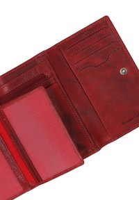 Red leather wallet interior with card slots, a zippered pocket, and a textured panel. Notable stitching details and branding visible.