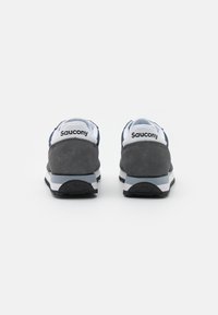 Grå og marineblå sneakers med overdel i semsket skinn, hvite detaljer og gummisåle. Har en polstret hæl og merkevare på baksiden.
