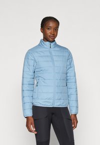 Giacca imbottita blu chiaro con colletto alto, caratterizzata da un motivo a righe orizzontali, cerniera frontale e tasche laterali. Indossata sopra pantaloni neri.