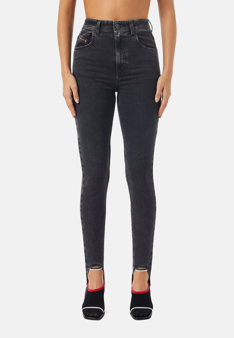 Jeans neri a vita alta con vestibilità slim, realizzati in tessuto denim. Presentano tasche frontali e un leggero orlo sfilacciato. Abbinati a tacchi aperti neri e rossi.