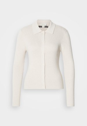 Kermanau ribbattu kardigaanilla, jossa on pitkät hihat, kauluksen muotoinen kaula-aukko ja nappisuljenta. Ominaisuuksina pehmeä tekstuuri ja slim-fit-muotoilu.