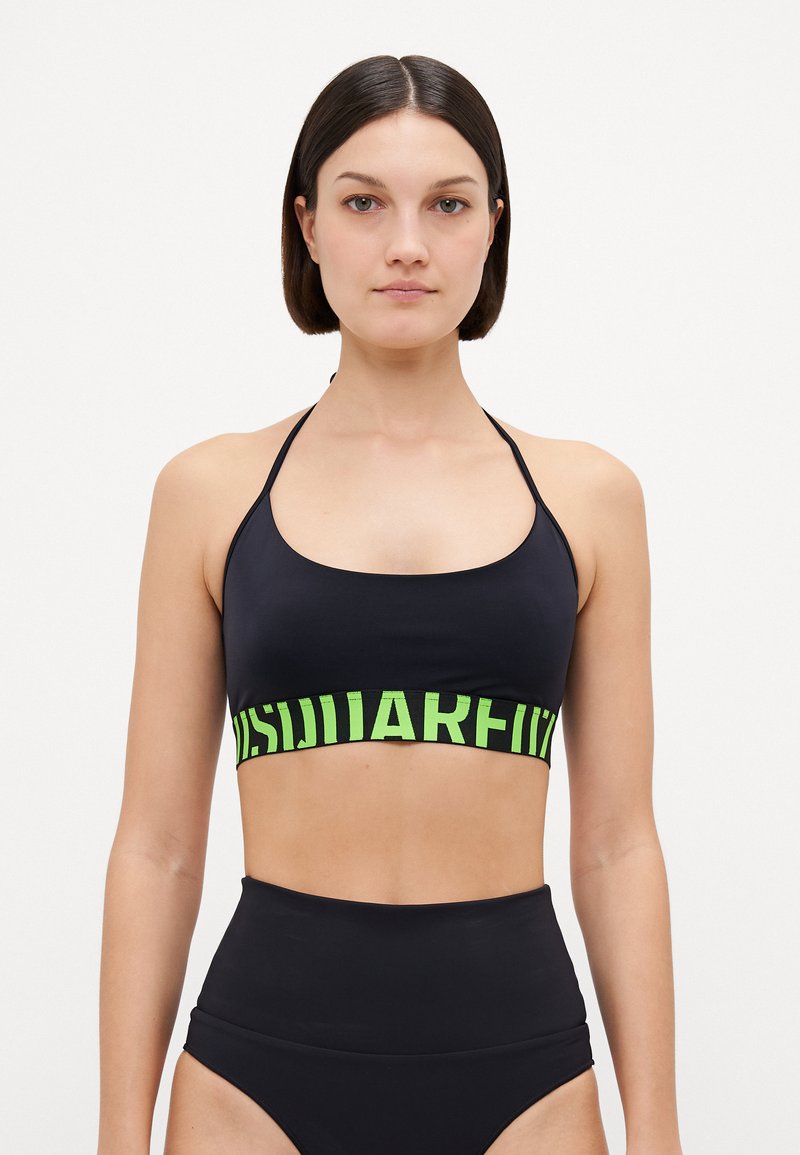 Black bikini top with a wide green band featuring text. The design includes thin shoulder straps and a fitted shape. Suitable for swimwear.