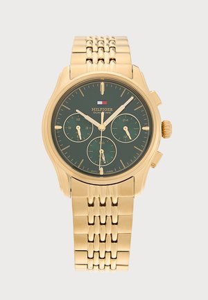 Reloj de pulsera de metal con tono dorado, esfera verde, tres subesferas y agujas doradas en una correa de eslabones dorada.