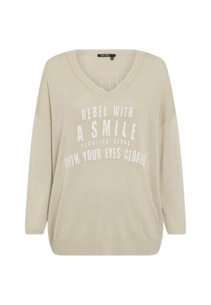 Beige sweater with a V-neck design, long sleeves, made of a textured, shimmery fabric. Features white printed text in a bold font.