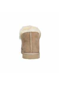 Tan suède enkellaarzen met een fluffy witte voering, een ronde neus en zichtbare stiksels langs de achternaad en onderrand.