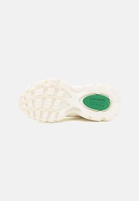 Semelle de sneaker Lacoste, en caoutchouc blanc texturé avec un logo ovale vert. Présente divers motifs de traction et un design de talon arrondi.