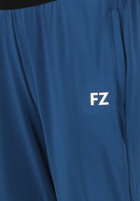 Blå idrottsshorts med vit "FZ" logotyp på högra låret, med en sidoficka och svart elastisk midja.