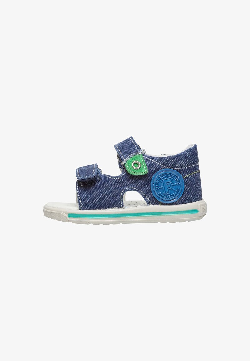 Sandal in denim blu con due fasce regolabili in velcro, accent verde e toppa rotonda con logo. Suola bianca con dettagli a strisce turchesi.