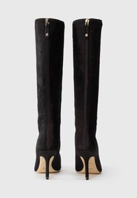 Fekete, térd fölé érő csizmák texturált anyagból, sima felülettel. Arany cipzárakkal és tűsarkú dizájnnal rendelkezik.