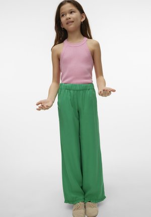 Sleeveless pink ribbed top paired with loose, green drawstring pants. Fabric is smooth; pants have ruffled cuffs. Worn with beige, textured shoes.