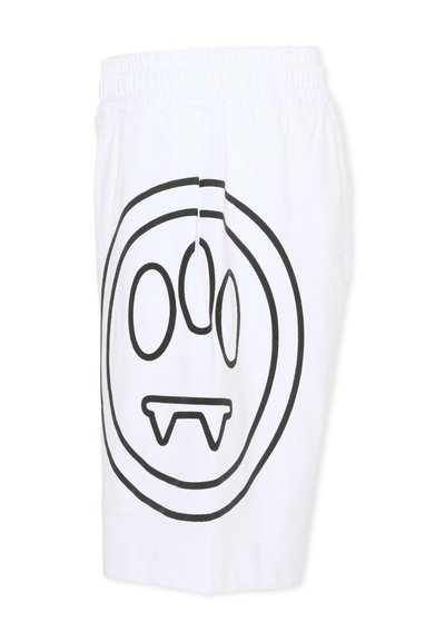 Shorts à taille élastique blanche avec un grand visage contour noir présentant des yeux ovales et deux dents pointues sur la jambe gauche.