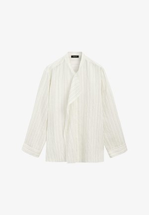 Blouse blanche à manches longues avec fines rayures verticales, panneau avant asymétrique et manches à revers.