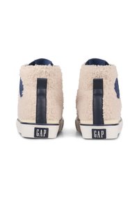 Krémové chlupaté vysoké tenisky s námořnickými akcenty, s texturovaným exteriérem, logem a kontrastní gumovou podrážkou.