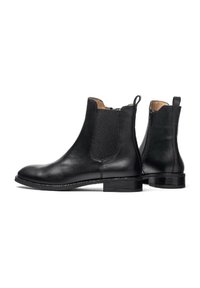 Stivali ankle in pelle nera con pannelli elasticizzati ai lati, punta rotonda e toppa per la trazione. Presentano un tacco basso a blocco e una texture liscia.
