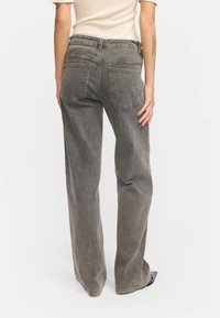 Graue weit geschnittene Jeans aus Denim, mit hoher Taille, Gesäßtaschen und einem entspannten Schnitt, in einem leicht verwaschenen Finish.