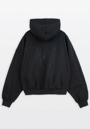 Czarna kapturowa bluza o krótkim kroju, zdobiona błyszczącymi elementami tworzącymi wzór na plecach. Wykonana z miękkiej, teksturowanej tkaniny.