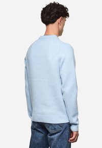 Hellblau gestrickter Pullover mit rundem Ausschnitt, gerippten Bündchen und Saum. Verfügt über einen strukturierten Stoff und klassische Silhouette.