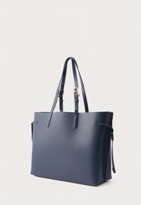 Tumši zils ādas tote somiņa ar teksturētu virsmu, divām augšējām rokturiem un sānu siksnu aizvēršanai. Aprīkota ar zelta toņa metāla akcentiem.