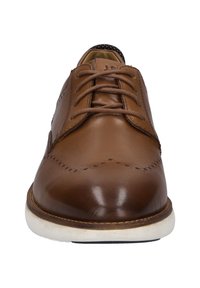 Braune Lederdressschuhe mit runder Zehenform, aufwendigen Nähten und flachen Schnürsenkeln. Weiße Sohle mit minimalem Profil für besseren Halt.