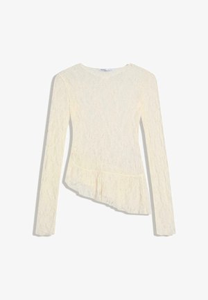 Long-sleeve cream lace top with round neck and asymmetrical ruffle hem, fitted silhouette.