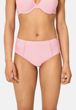 Mujer con top de bikini de rayas verticales rosas y blancas y braguitas de bikini de talle alto sobre un fondo liso.