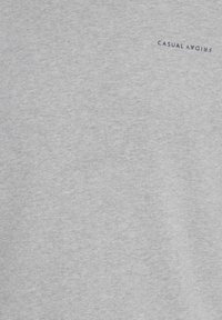 Graues Baumwoll-T-Shirt mit weichem Material. Verfügt über ein kleines, navyfarbenes "CASUAL FRIDAY"-Logo auf der oberen linken Seite. Standardmäßiger Rundhalsausschnitt.