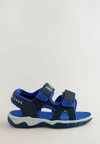 Kinderblaue und schwarze Sandale mit offenem Zehenbereich, verstellbaren Klettverschlüssen und einer strukturierten Gummisohle.