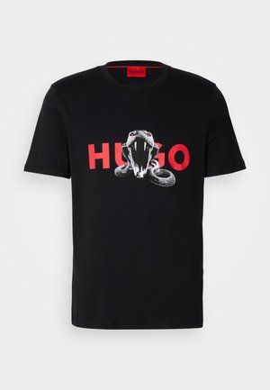 Black cotton t-shirt featuring a graphic of a snake with red accents and "HUGO" text in bold red letters beneath it. Short sleeves, crew neck design.