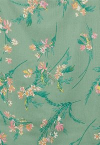 Grüner Stoff mit einem zarten Muster aus kleinen rosa, weißen und gelben Blumen sowie dünnen grünen Stängeln, die über die Fläche verteilt sind.