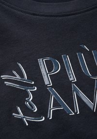Sudadera de tejido navy con letras en relieve en blanco y azul, con una textura suave y elementos de diseño gráfico en contraste.