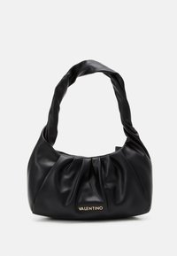 Svart läderhandväska med en snodd handtag och samlad design. Har en gyllene varumärkesdetalj på framsidan. Slät textur.