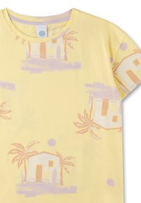 Gelbes Baumwoll-T-Shirt mit einem sich wiederholenden pastelartigen Muster von Strandhäusern und Palmen, mit Rundhalsausschnitt und kurzen Ärmeln.