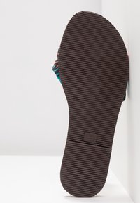 Infradito con parte superiore decorata nei colori teal, rosa e nero, suola in gomma marrone con linee di presa testurizzate e logo del marchio.