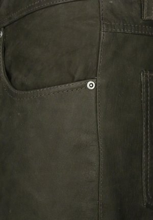 Zwarte leren kledingstuk met een zichtbare zak en metalen hardware accenten. Heeft een soepele textuur en contrasterende stikseldetails.