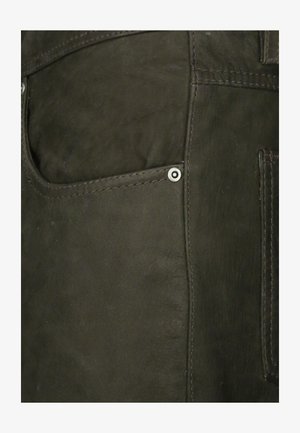 Black leather garment with a visible pocket and metal hardware accent. Features smooth texture and contrasting stitching details.